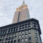 A stunning low-angle shot of the Empire State Building towering above the New York skyline.